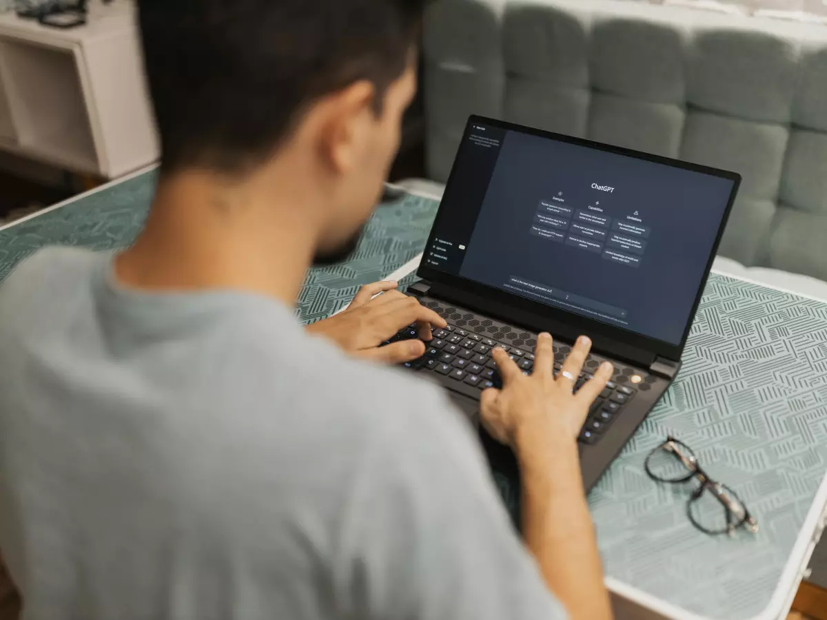 A person is working on a laptop, the laptop is open and the screen is showing a presentation with some text and bullet points.