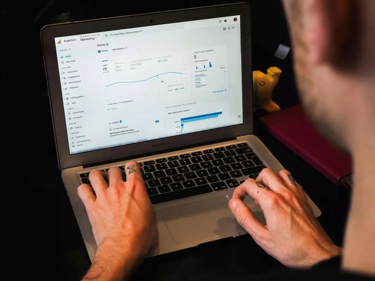 A person is working on a laptop, analyzing data charts displayed on the screen. The image highlights the key aspect of data analysis and understanding in the context of machine learning.