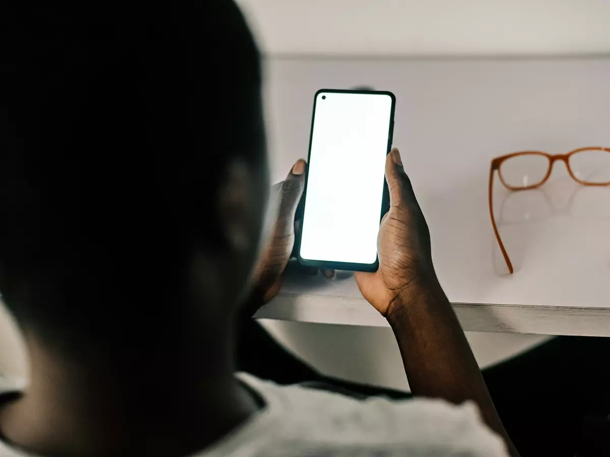 A person holding a smartphone in their hands, with the screen facing the viewer.