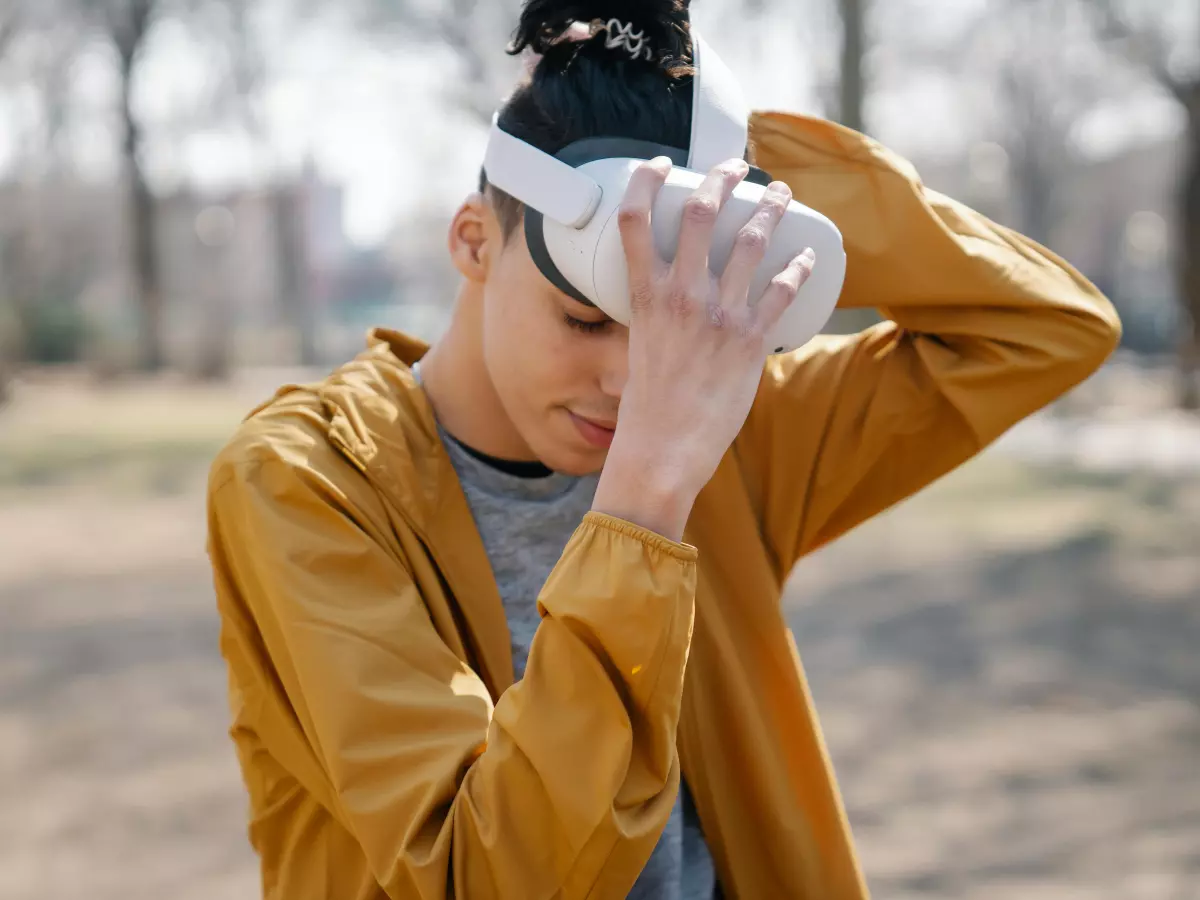 A person is wearing a VR headset in a park setting. 