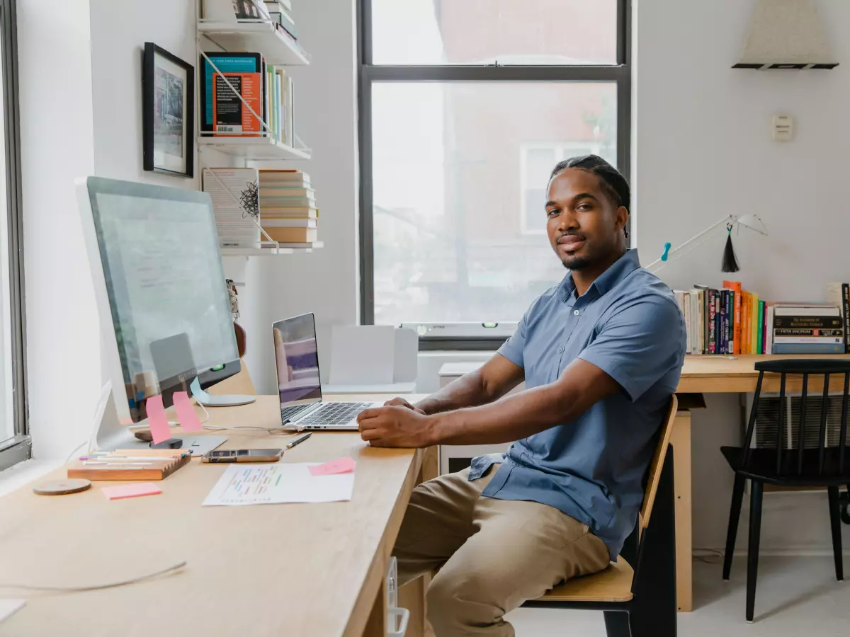 A man sitting at a desk in front of a computer, working.