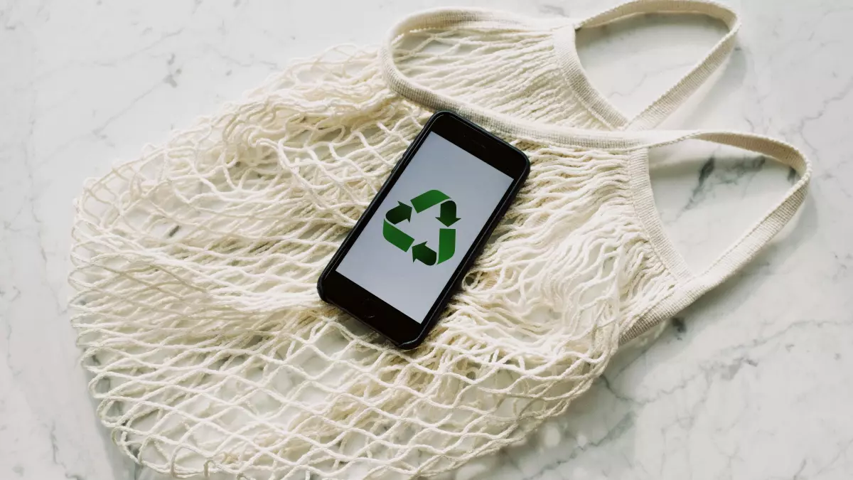 A close-up shot of a hand inserting a small, lime-green battery pack into a sleek, modern recycling slot. The overall image appears clean and futuristic, suggesting efficient and user-friendly EV battery recycling technologies.