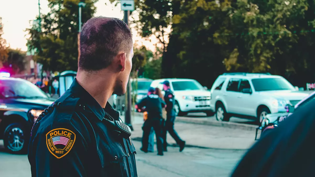 A police officer is arresting a person in the background. 