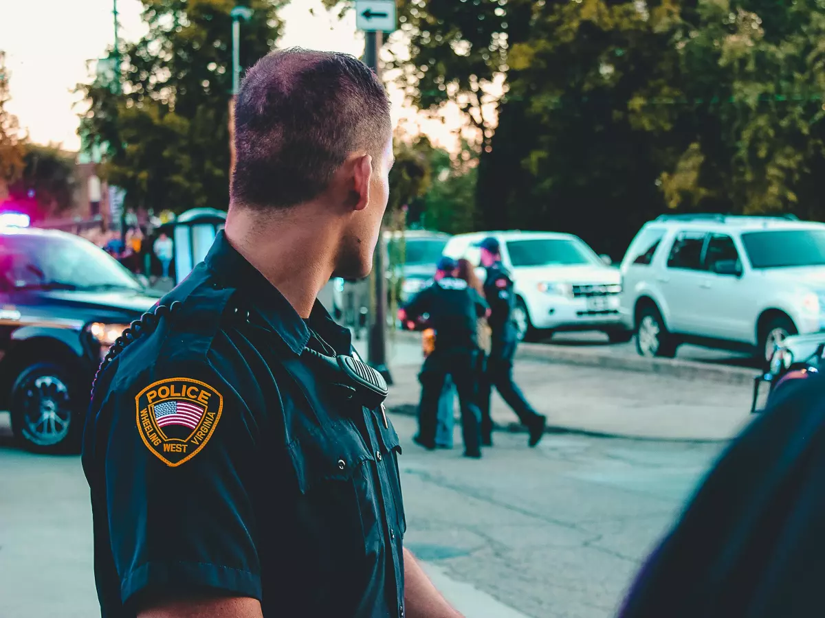 A police officer is arresting a person in the background. 