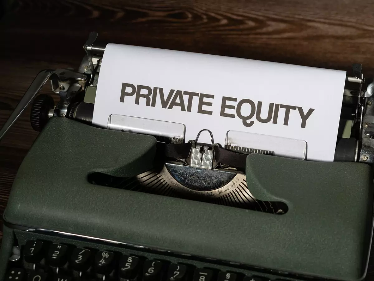 A vintage typewriter with a piece of paper that says "PRIVATE EQUITY" in it.