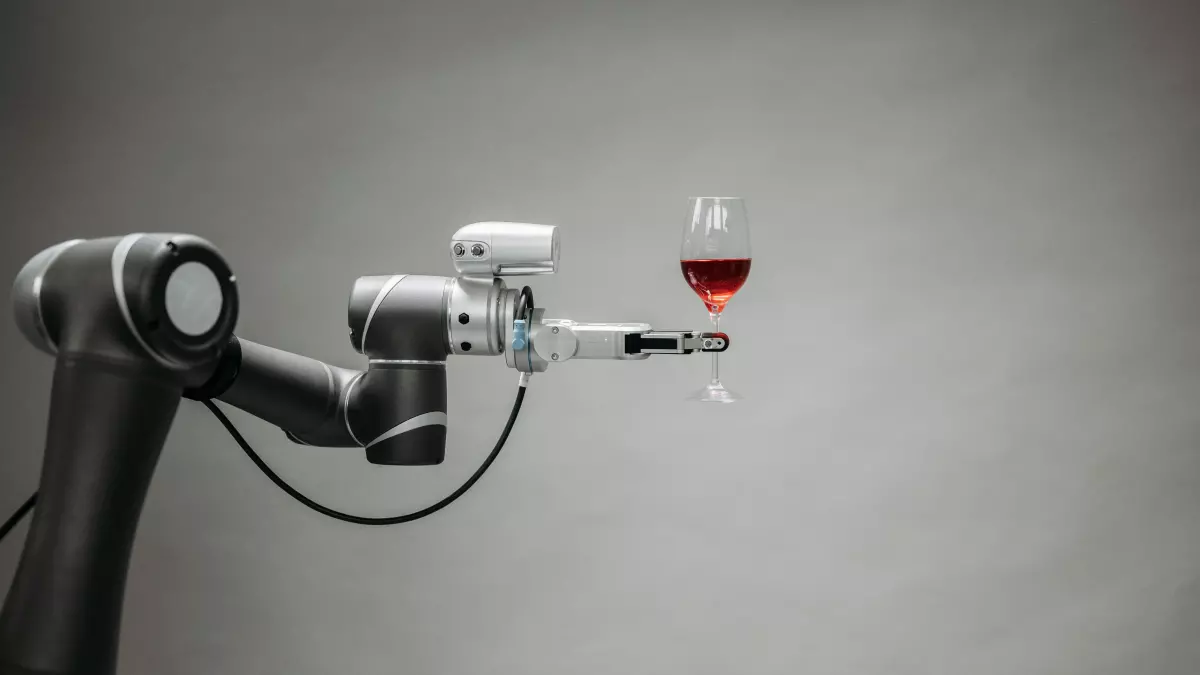 A robotic arm pours wine into a glass.