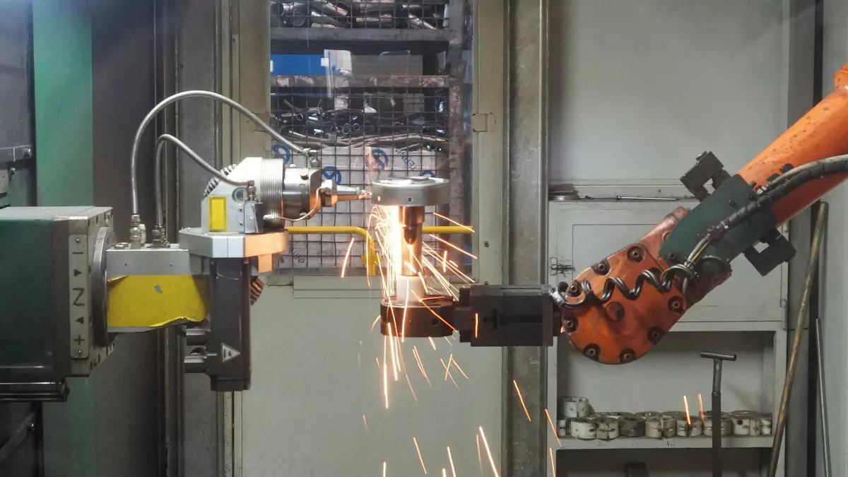 A robotic arm with sparks flying from its welding process.