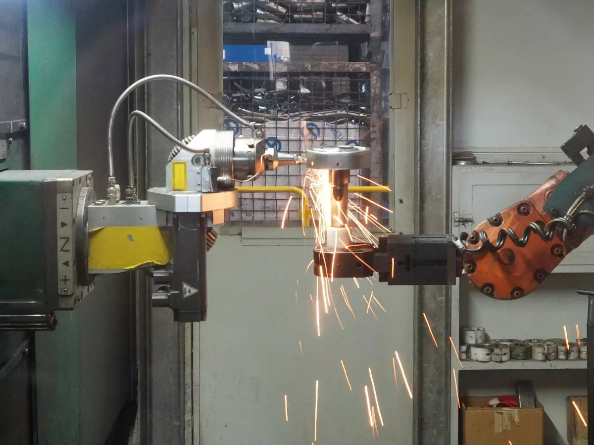 A robotic arm with sparks flying from its welding process.