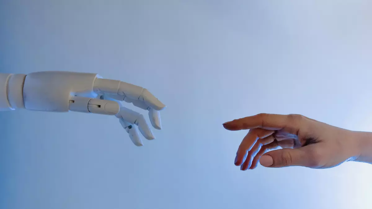 A close-up shot of a human hand and a robotic hand reaching out to each other.