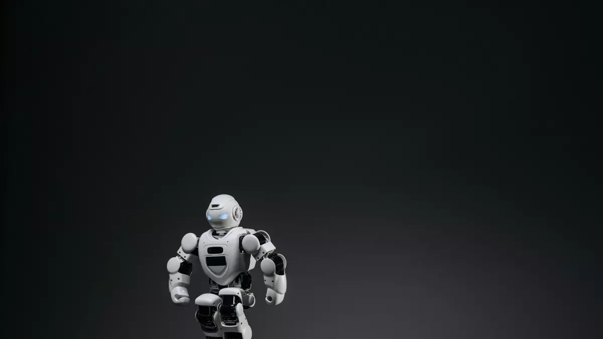 A white humanoid robot with black joints, standing on a circular platform.