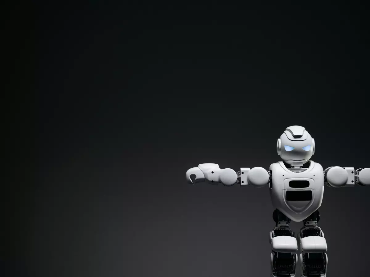 A white humanoid robot with outstretched arms against a black background. The robot's design and sensor placement are clearly visible.