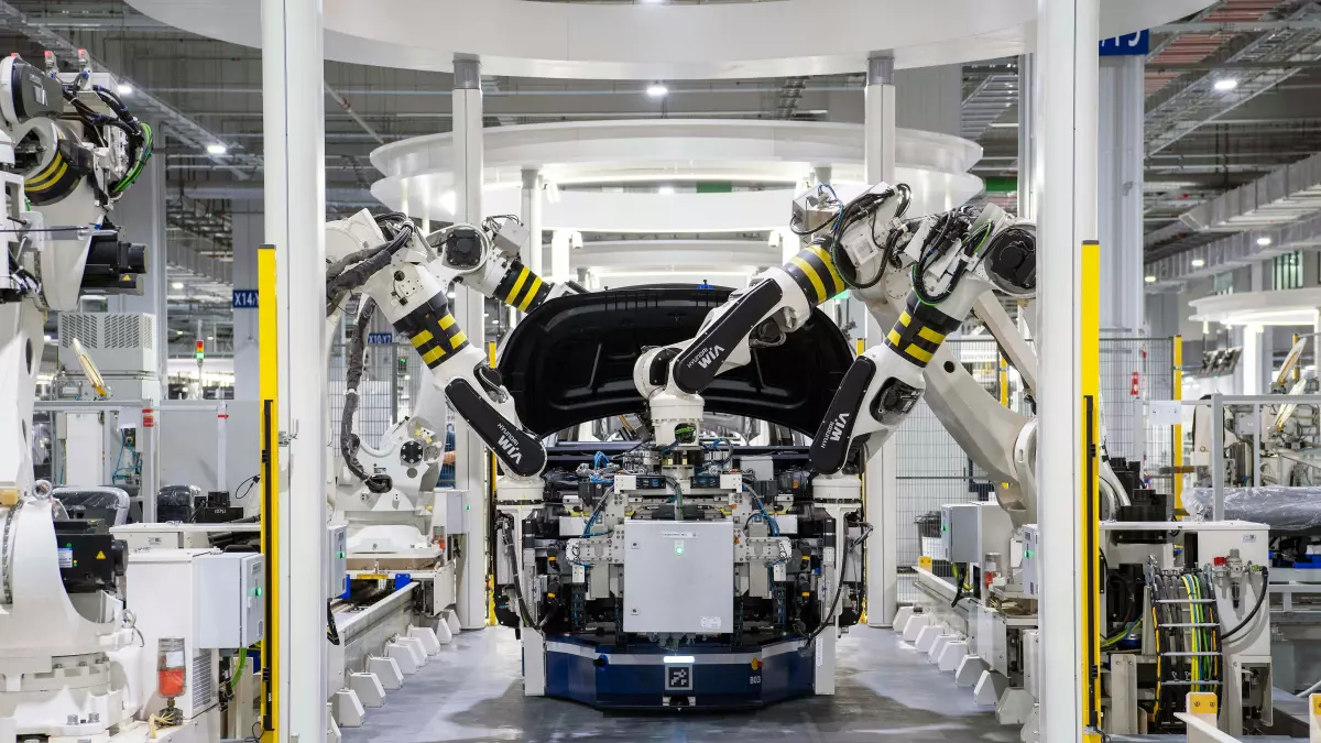 A close-up view of two robotic arms working in a factory setting.