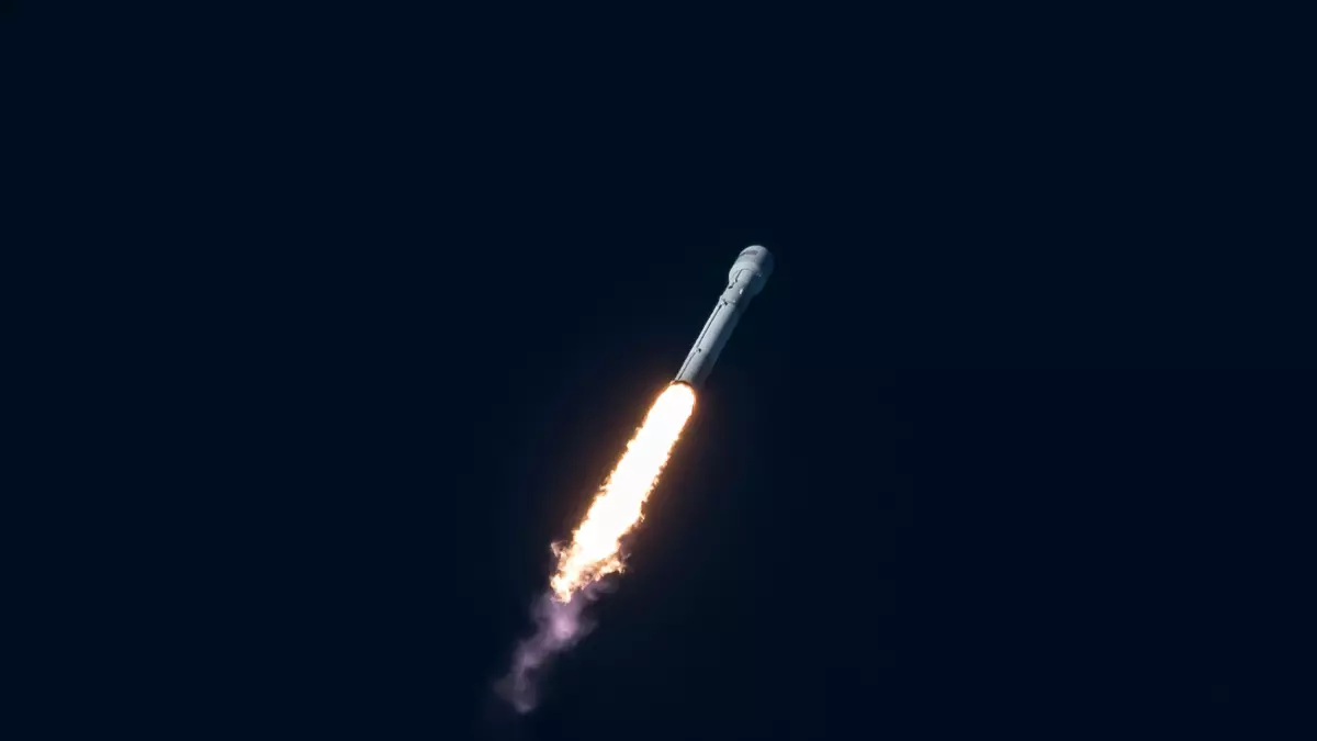 A rocket launches into the night sky, leaving a trail of fire and smoke behind it.