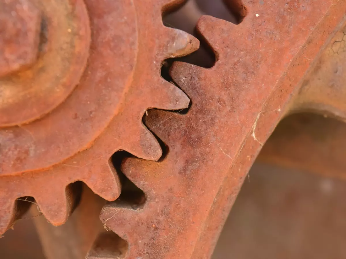 Close-up shot of two rusty gears that are interlocked together. 