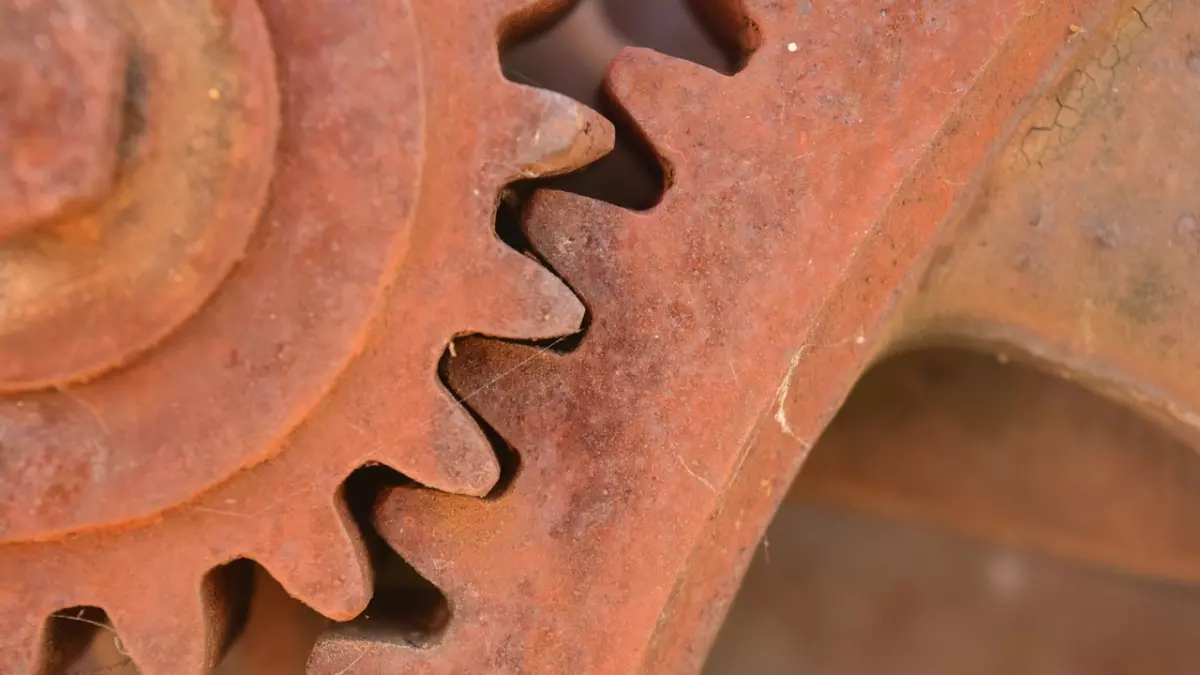 Close-up shot of two rusty gears that are interlocked together. 