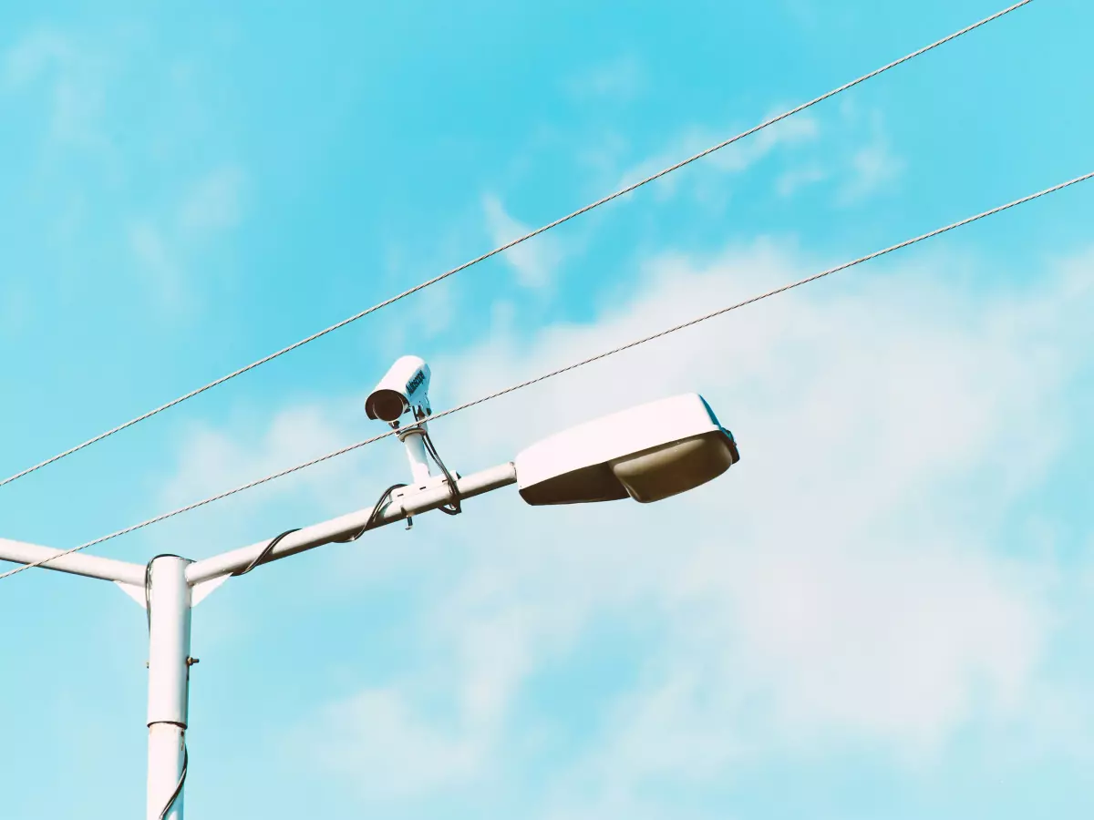 Close-up of a surveillance camera mounted on a brick wall.