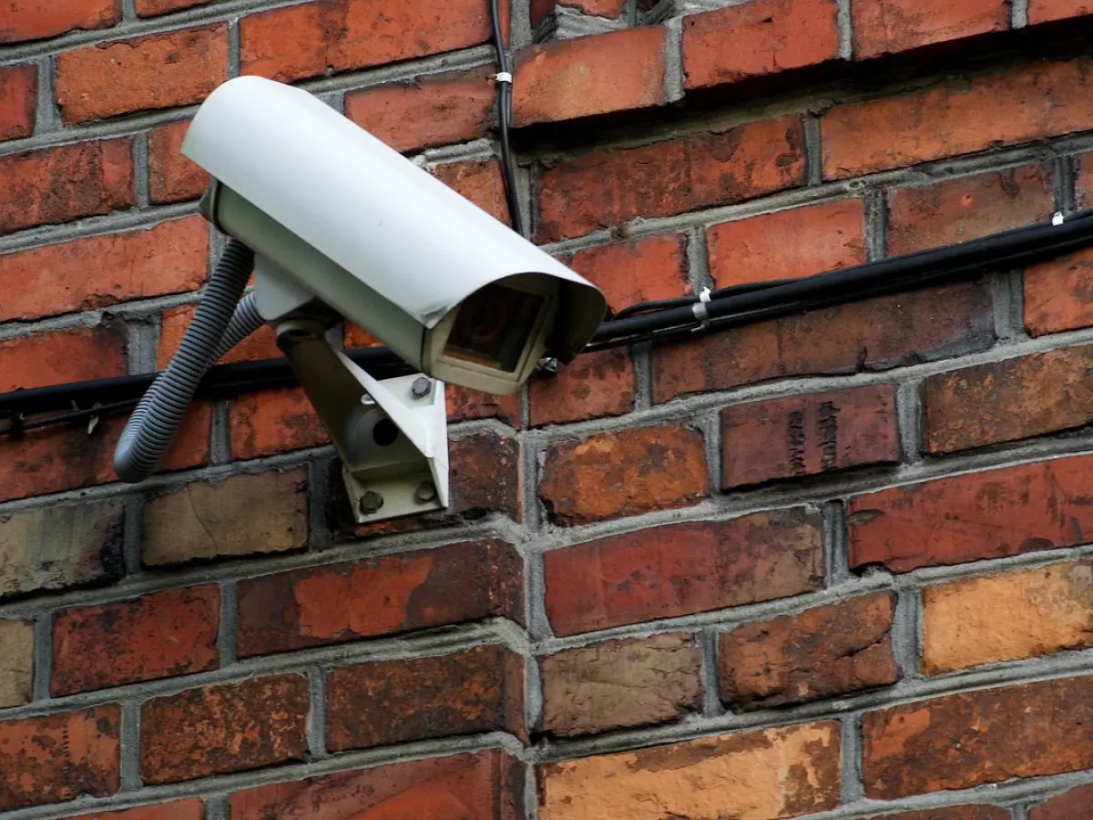 A single security camera mounted on a brick wall.