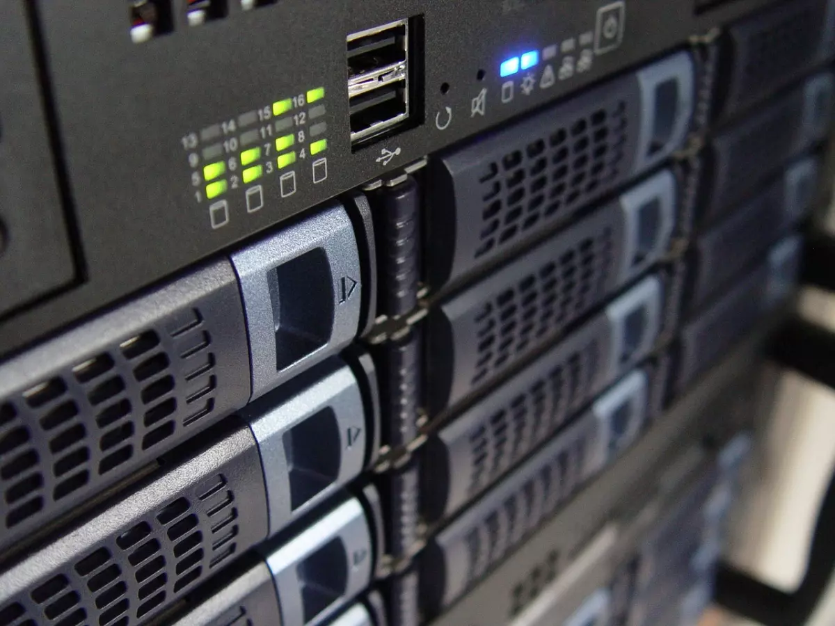 A close-up shot of a server rack with multiple bays. The rack is made of black metal with a silver trim. The front panel is a black plastic with a series of buttons, lights, and ports. The bays are filled with hard drives.