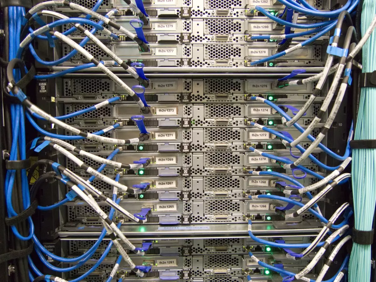 A close-up of a server rack in a data center, showing a variety of cables and hardware.