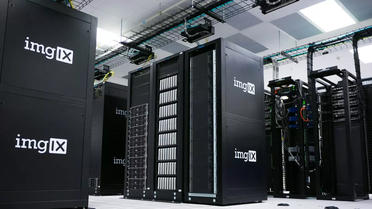 A server room with rows of black servers, all with the same logo. The servers are in a white room, with cables running overhead.