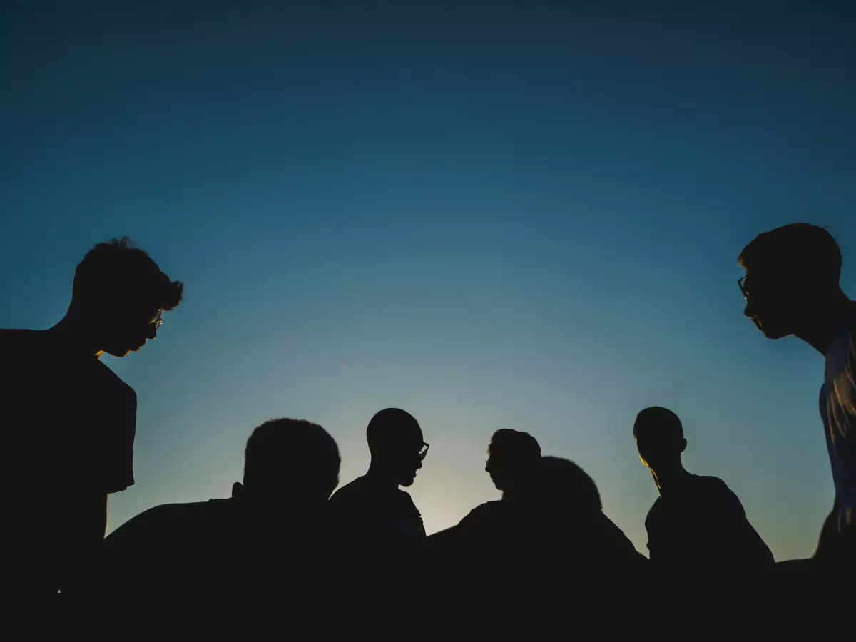 Silhouettes of people talking and working together.