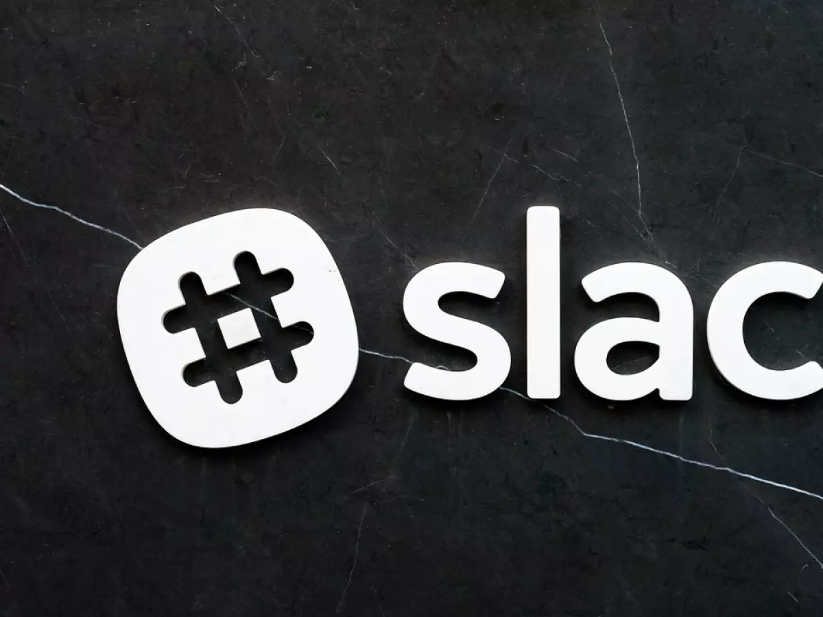 The Slack logo, white on a black marble background