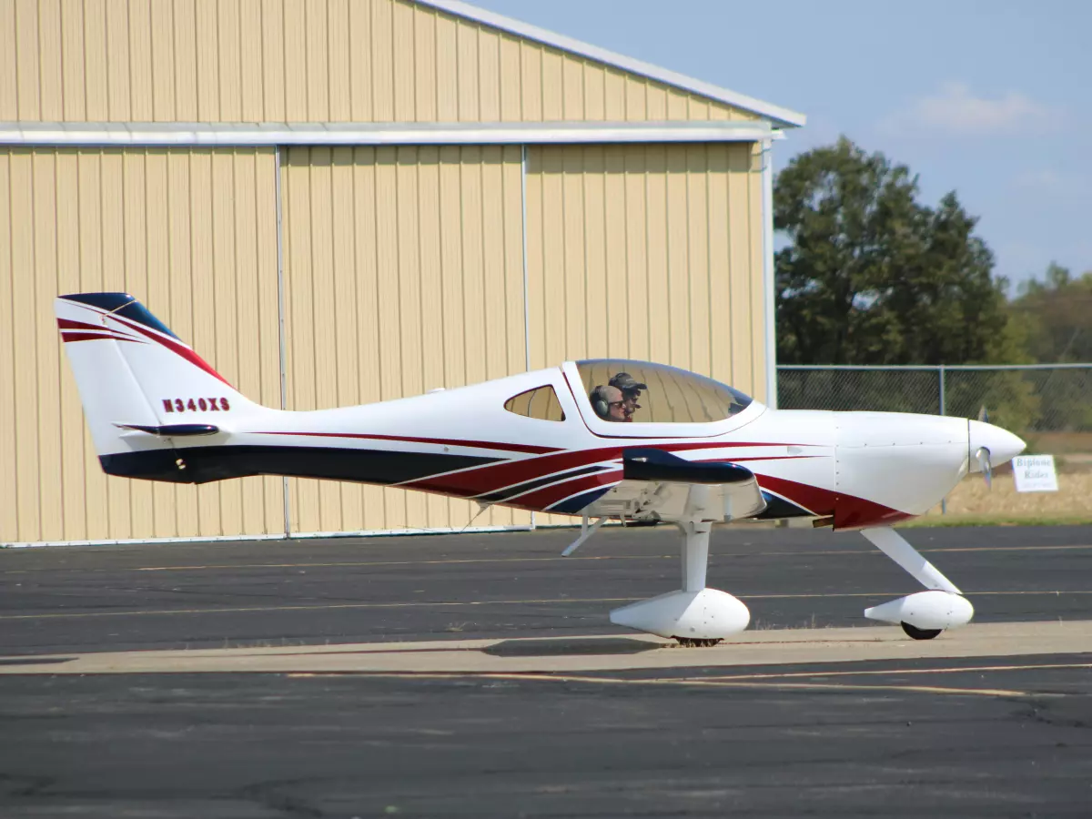 A small, white and red electric aircraft with its propellers visible.