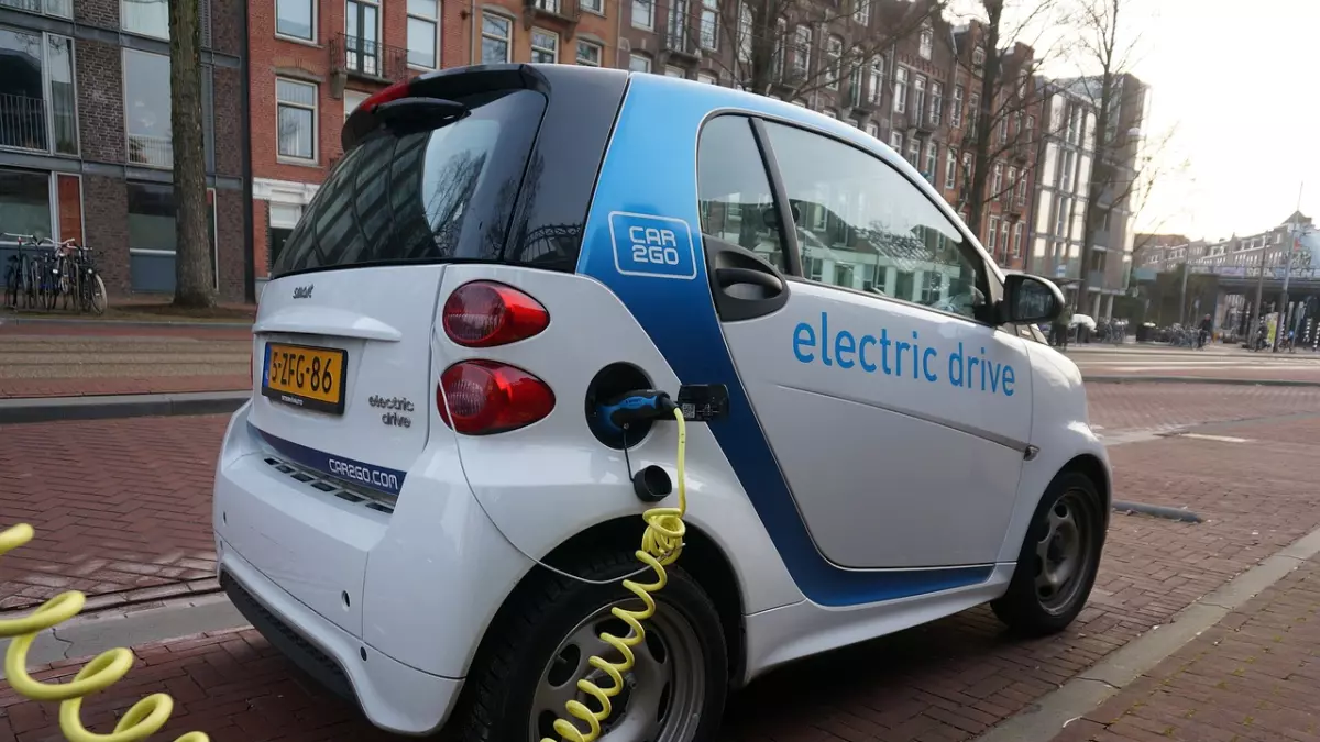 A white electric car plugged into a charging station.