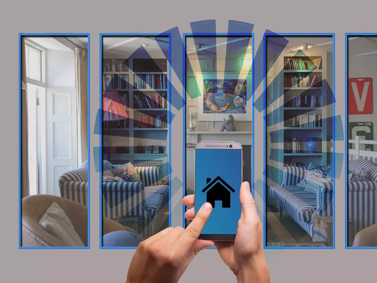 A person is holding a smartphone in front of a montage of four different rooms. The smartphone screen shows a house icon, suggesting that the person is controlling the smart home devices.