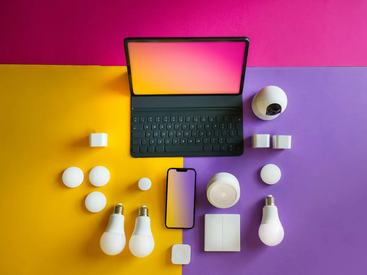 A flat lay of smart home devices on a colorful background.