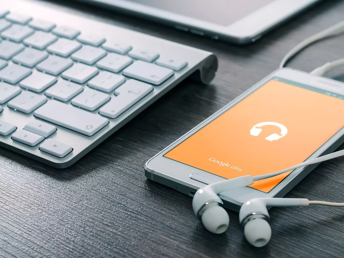 A collection of gadgets arranged on a table, including a drone, a smartphone, headphones, a watch, and a speaker.