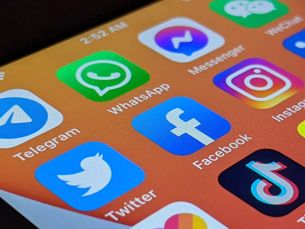 A smartphone screen displays a grid of popular social media app icons, including Facebook, Instagram, TikTok, Snapchat, Messenger, WhatsApp, Telegram, and LinkedIn.