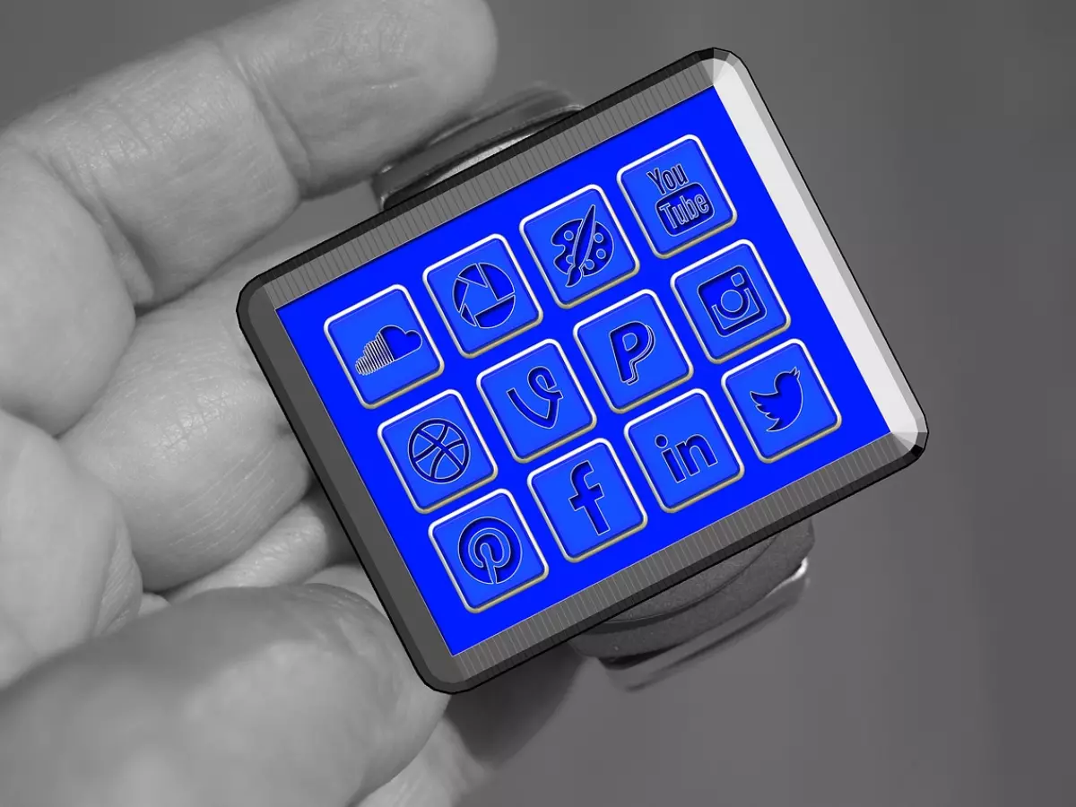 A smartwatch with a blue screen displaying various social media app icons.