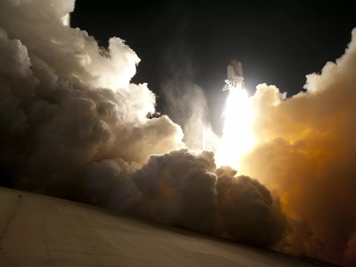 A rocket launching into the sky, with a large amount of smoke and fire behind it. It's a dramatic and exciting image.