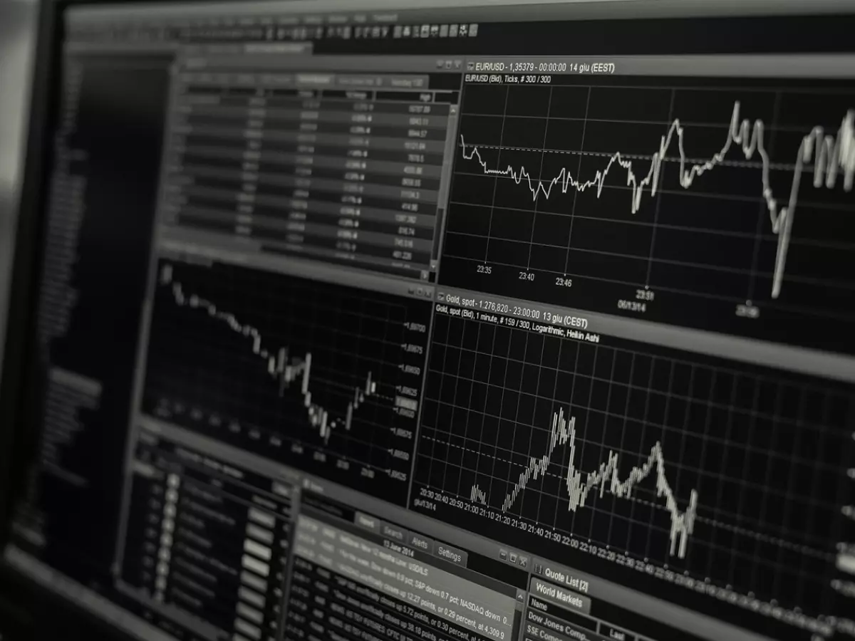 Close-up of a computer screen showing financial data and graphs. The screen is dark with light gray lines for the charts. The data is in numbers and percentages.