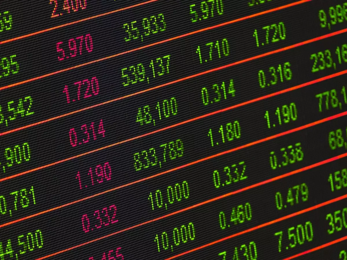 A close-up of a stock ticker with a black background, green and red numbers are displayed with red lines separating the rows of numbers.