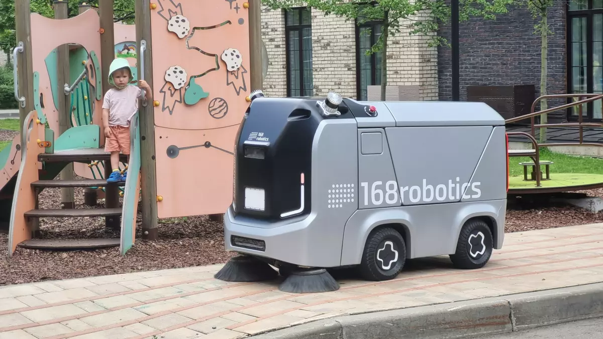 A close-up shot of a silver autonomous vehicle,  with the brand name 