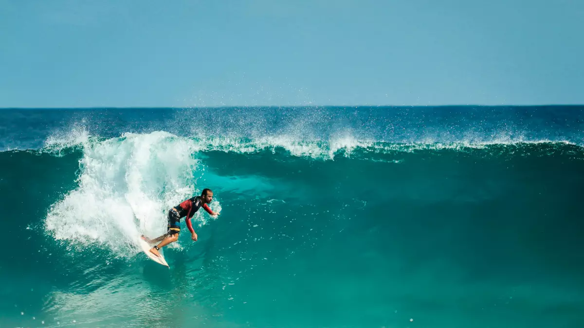 A surfer rides a large, powerful wave in the ocean.