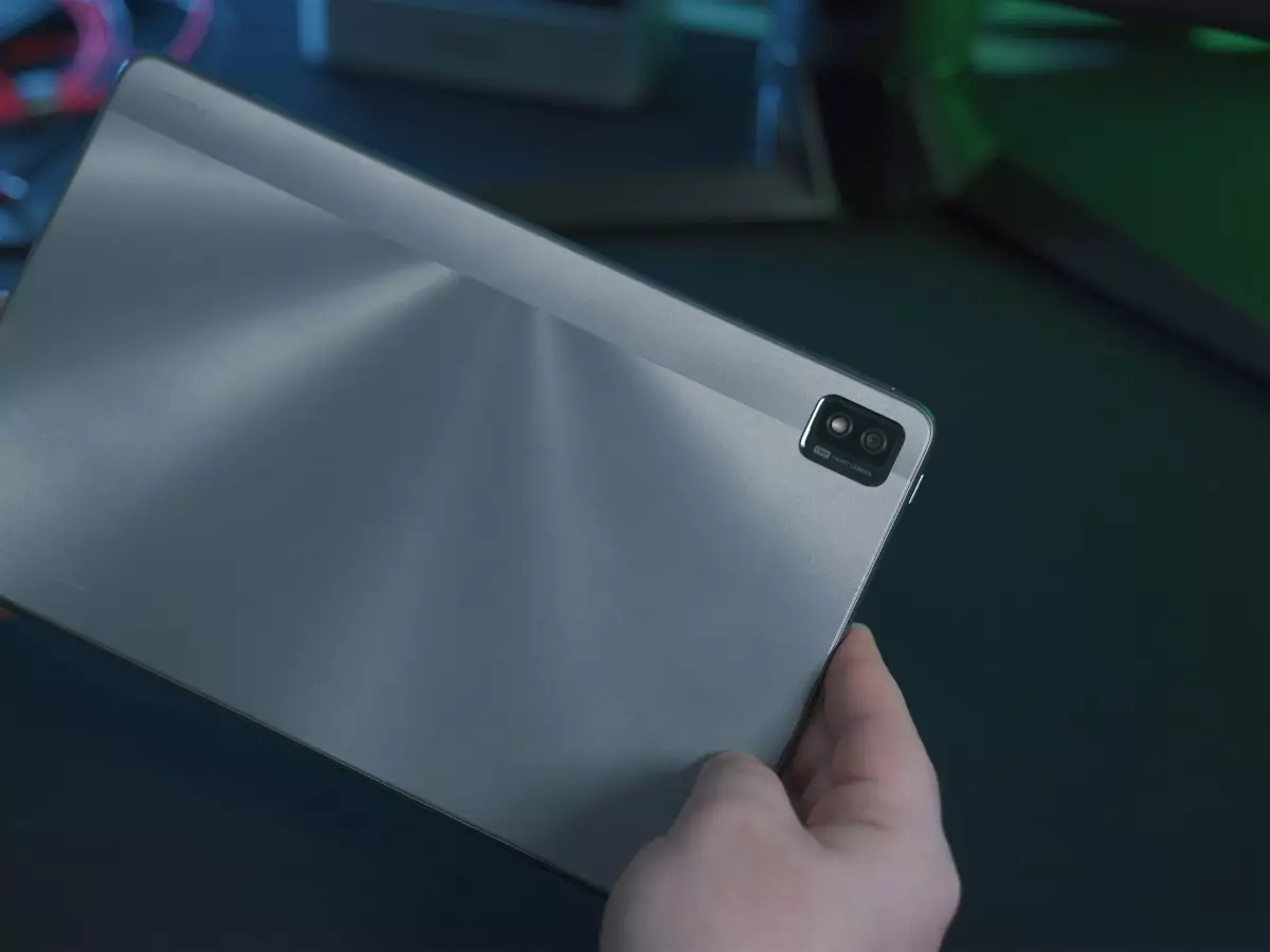 A person holding a large, silver tablet, showcasing its smooth surface and design.