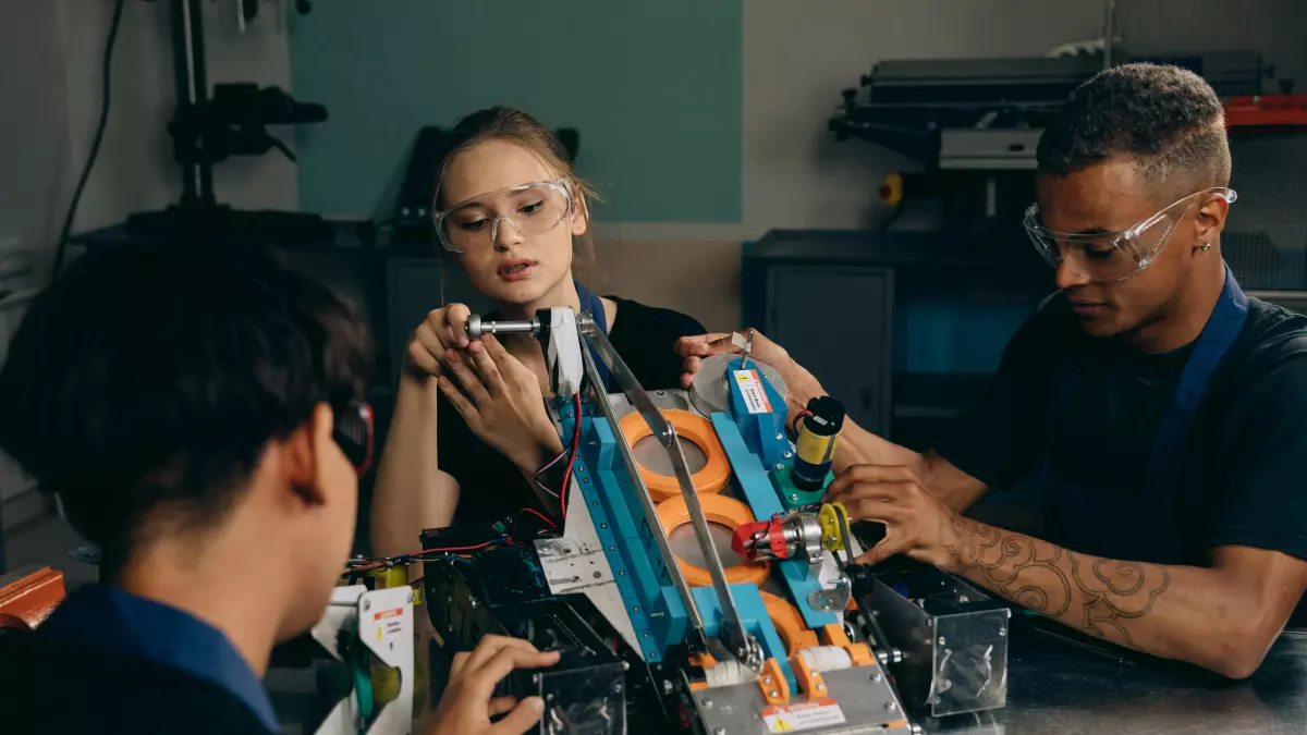 A group of people working on a robot, the focus is on a woman