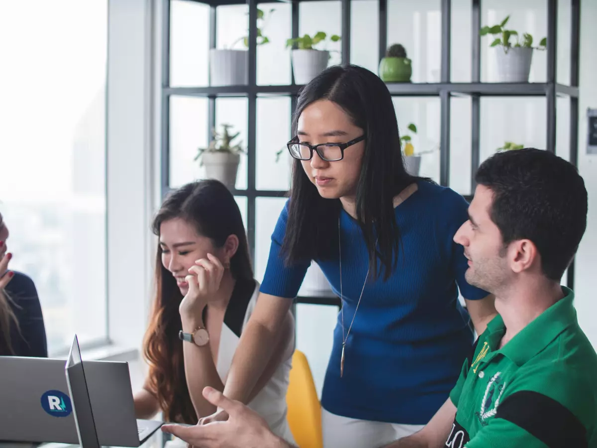 A group of people working on a computer in an office