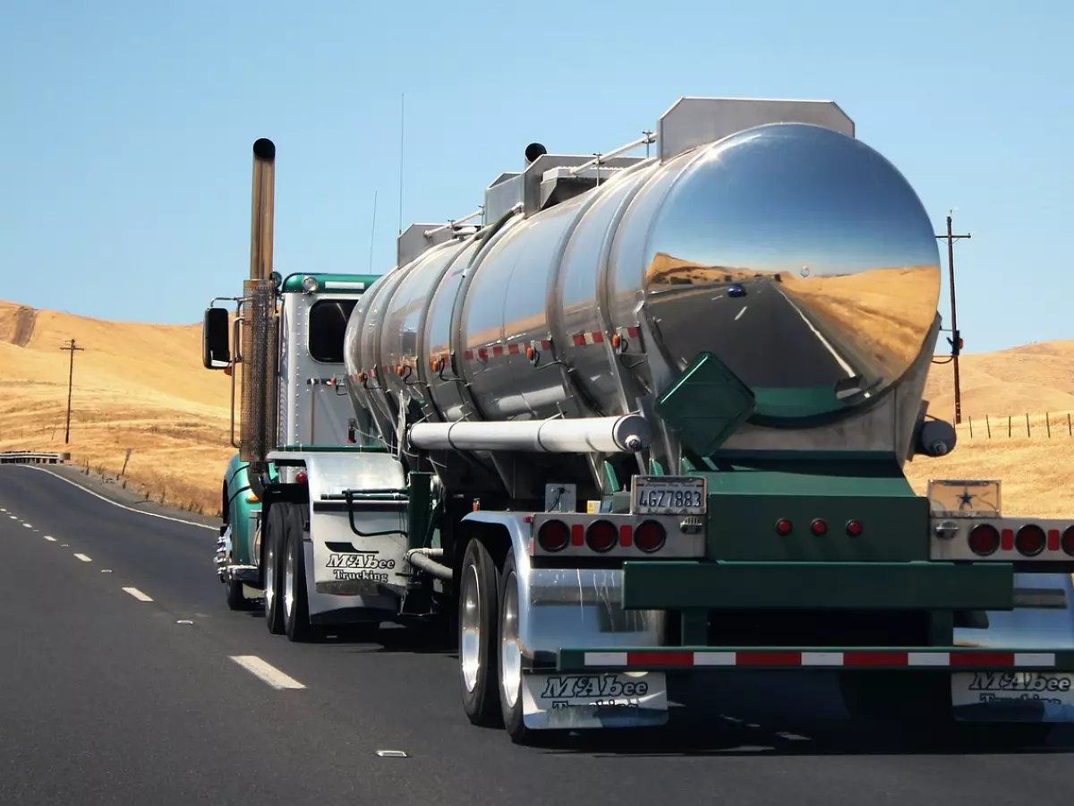 A semi-truck tanker on a highway.