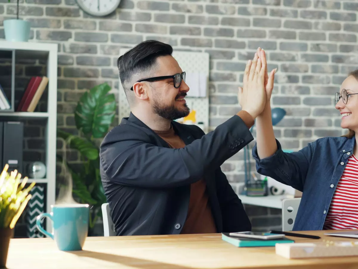 Two people working together at a desk in an office.