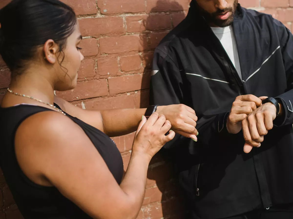 Two people checking their smartwatches