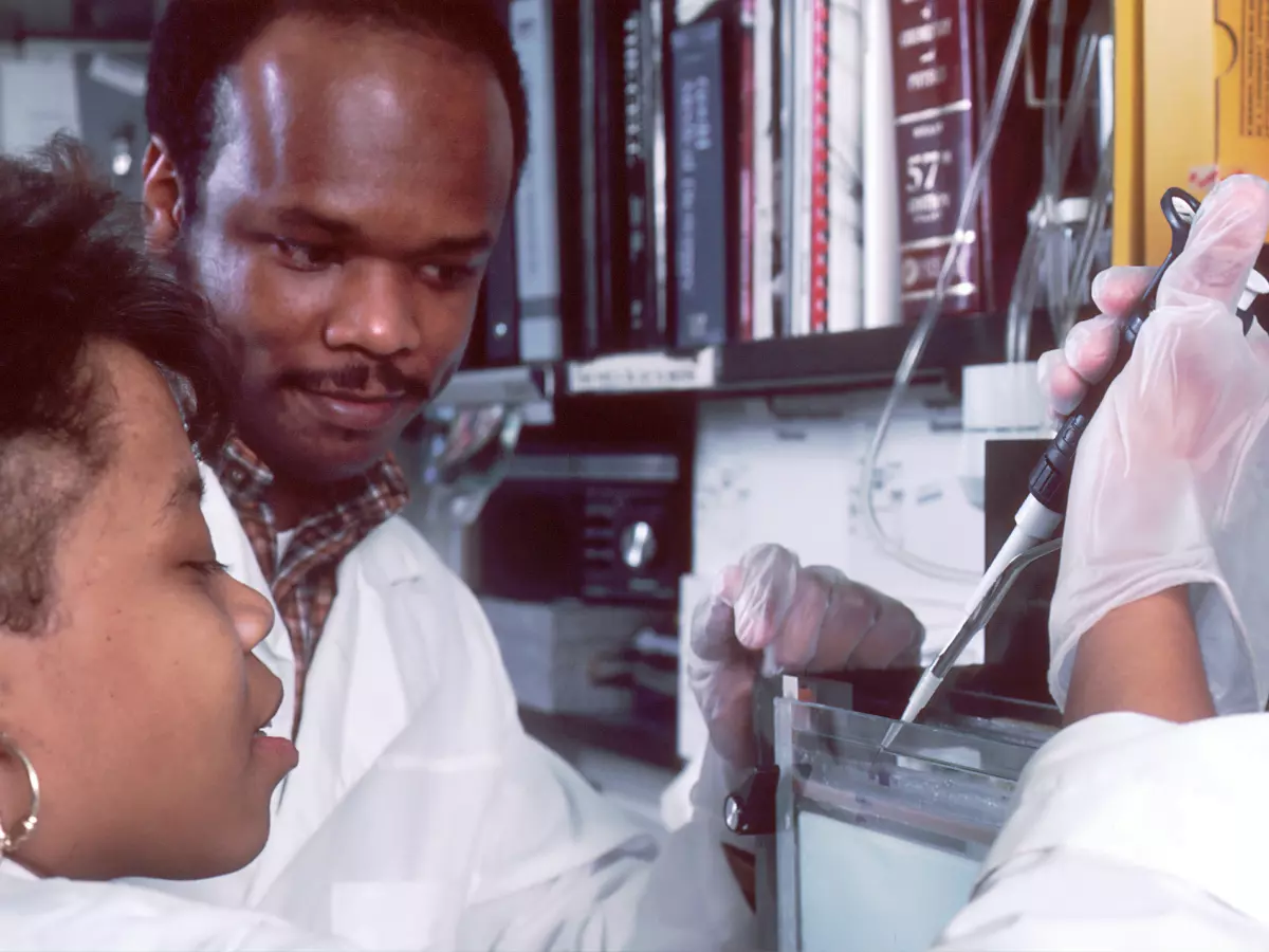 Two scientists in a lab working on a genetic sample.