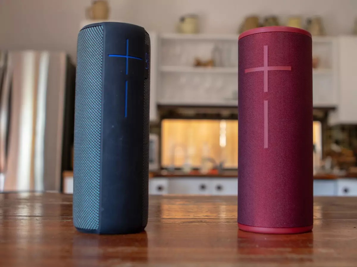 Two different brands of Bluetooth speakers placed on a table