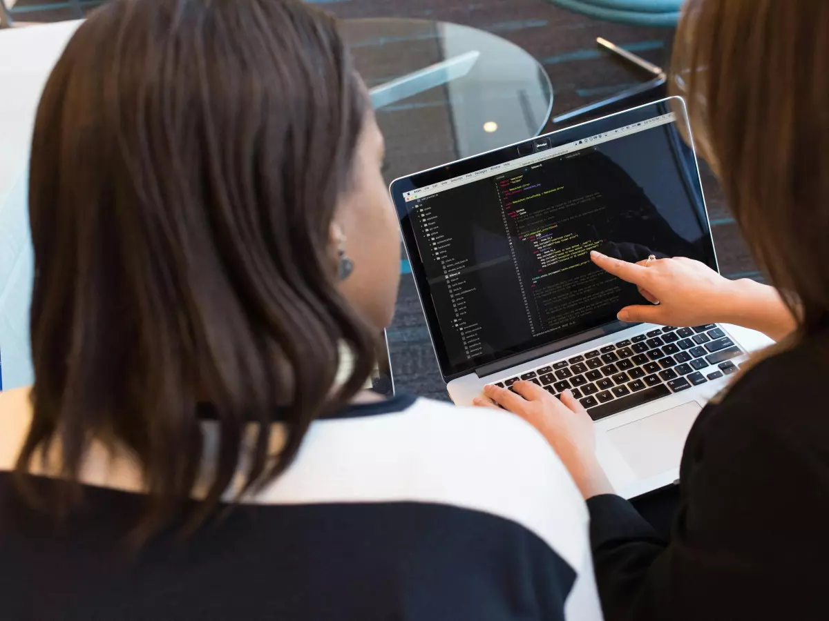 Two developers working on a laptop.