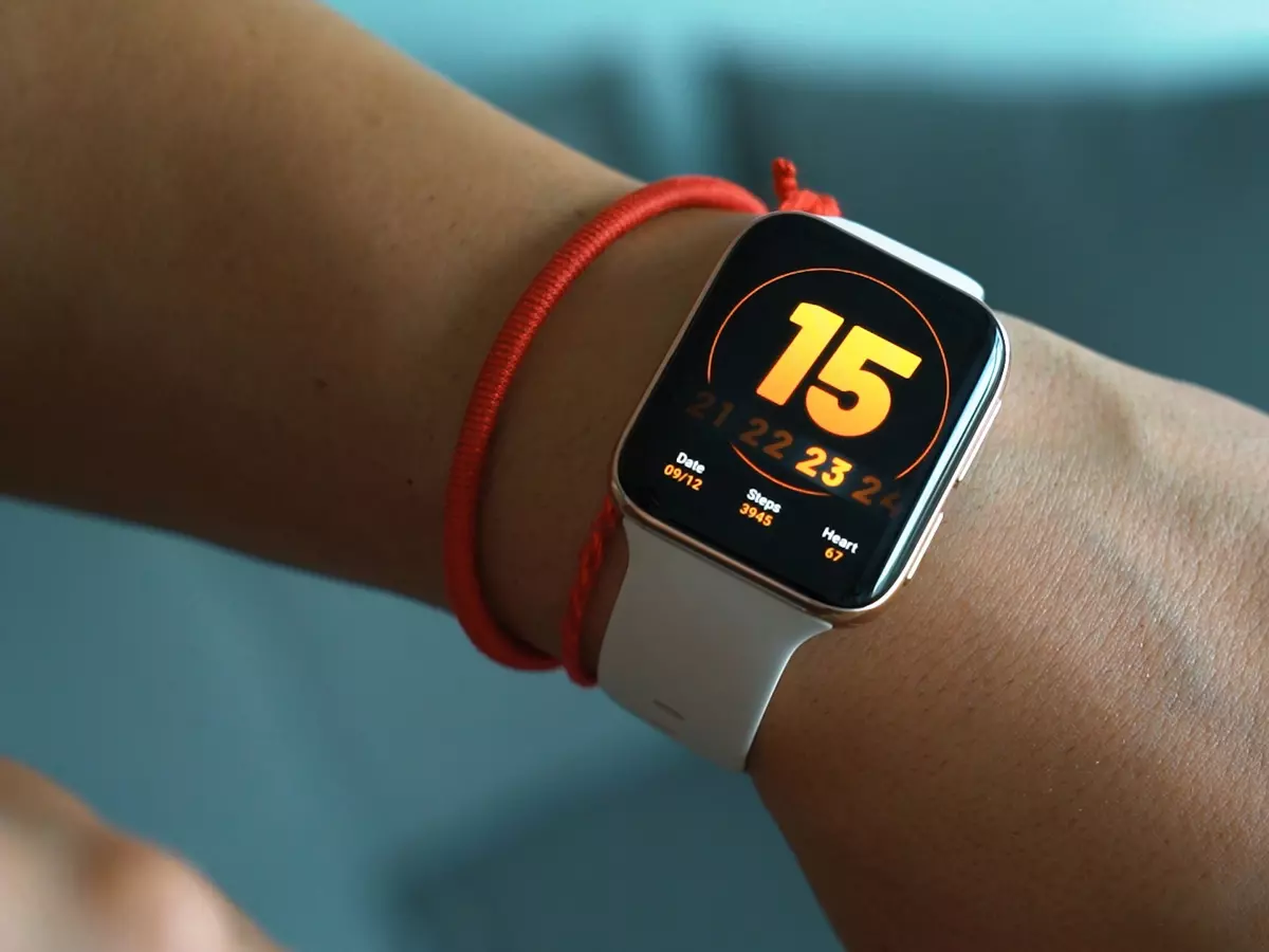 A person wearing a white smartwatch on their left wrist.