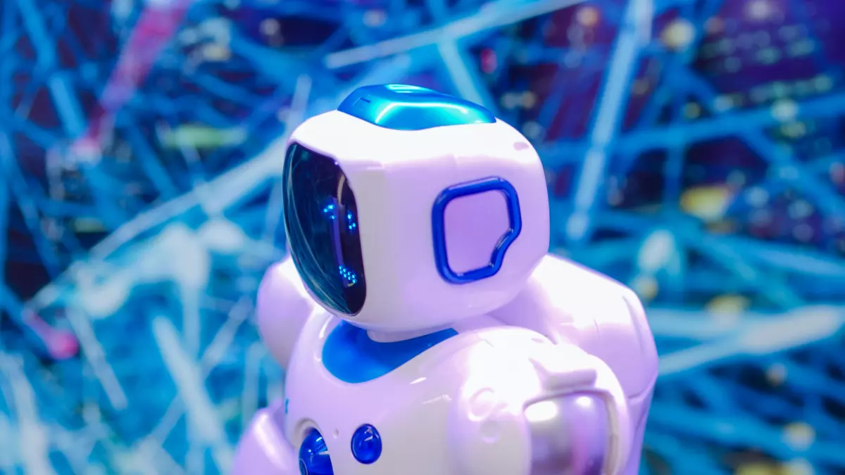 A white humanoid robot with blue accents stands in front of a blue and white abstract background. The robot