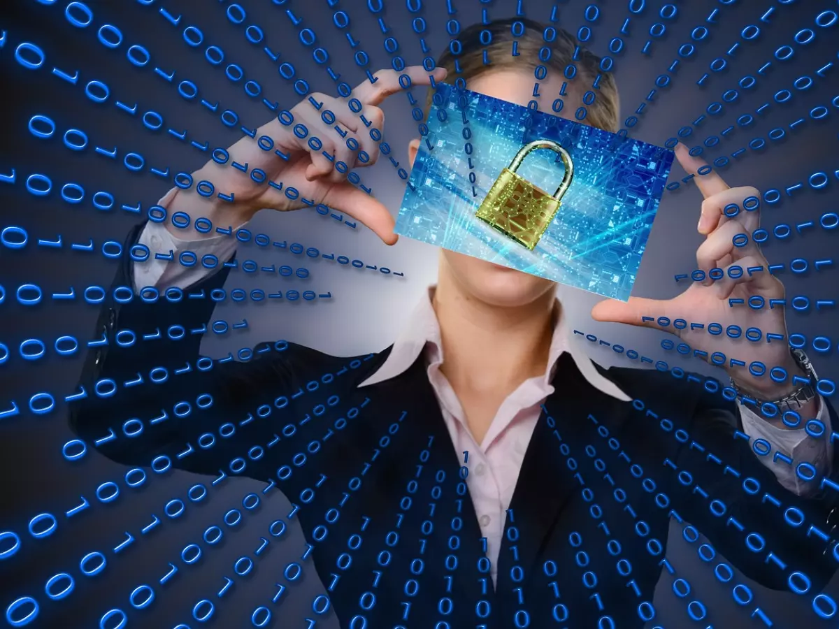 A woman in a black suit holding a padlock in front of her face, with a binary code background.